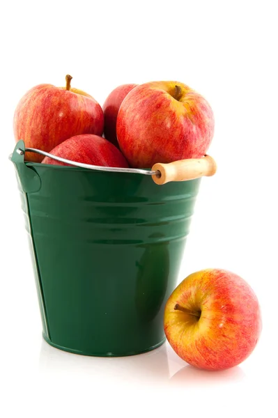 Gröna hinken med röda äpplen — Stockfoto