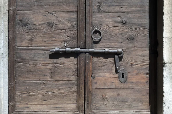 Old wooden door with metal bolt — Stock Photo, Image