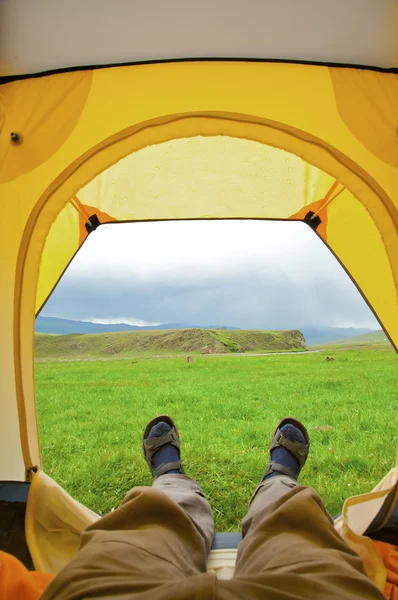 Człowiek leżący w namiocie z widokiem na góry — Zdjęcie stockowe