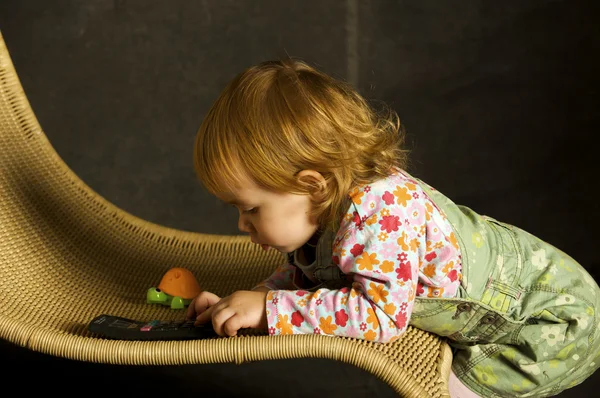 Meisje speelt op de leunstoel — Stockfoto