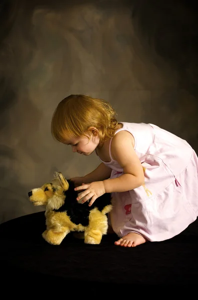 Дівчина грає з іграшковим собакою — стокове фото