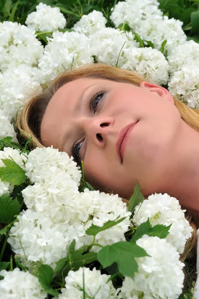 Jonge vrouw leggen in bloemen — Stockfoto