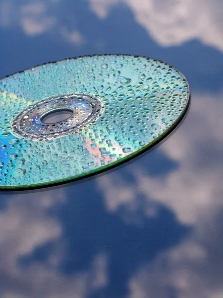 CD and water drops over blue sky — Stock Photo, Image