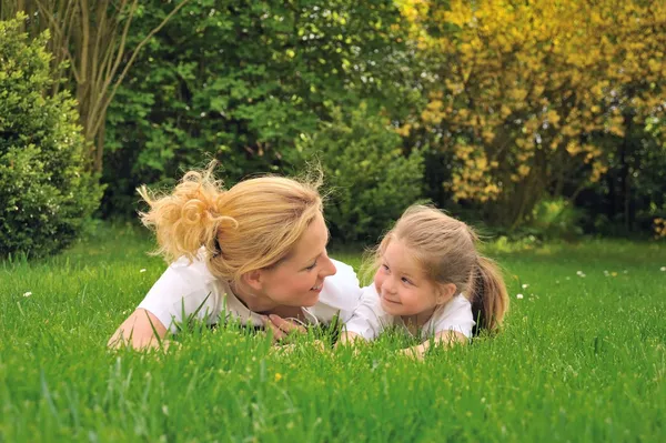 Молодая мать и дочь на траве — стоковое фото