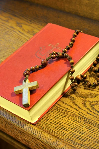 Libro de himnos y rosario de madera — Foto de Stock