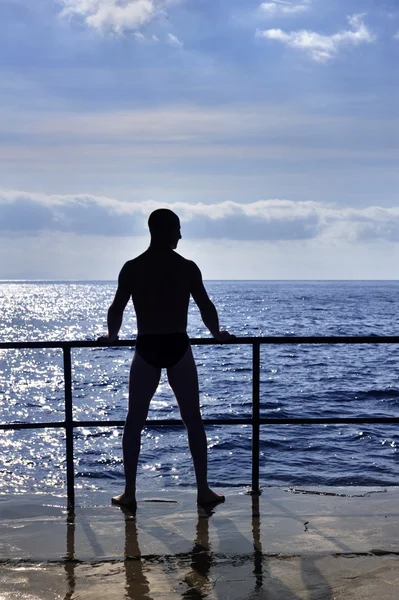 年轻男子站在海边的侧面影像 — 图库照片