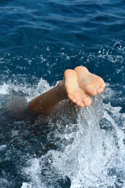 Молодой человек прыгает в воду — стоковое фото