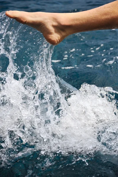 Нога молодого человека в воде - всплеск — стоковое фото