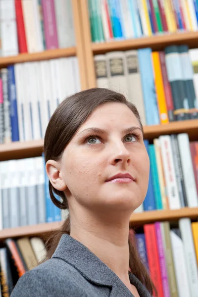 Mujer joven en la biblioteca — Foto de Stock