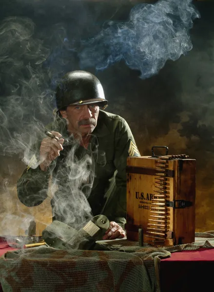 Человек в военном стиле в сигарном дыму — стоковое фото