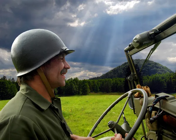 Человек за рулем военного джипа — стоковое фото