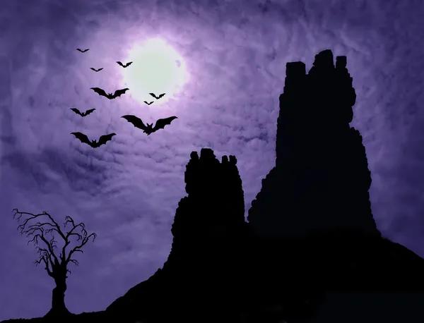 Темные руины и жуткое дерево с летучими мышами — стоковое фото