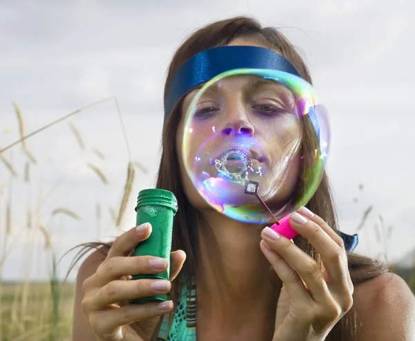 Visage de femme qui souffle des bulles de savon — Photo
