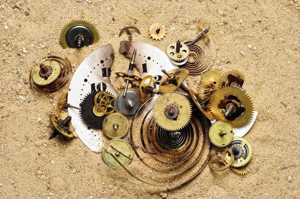 Delar av clockwork mekanism på sanden — Stockfoto
