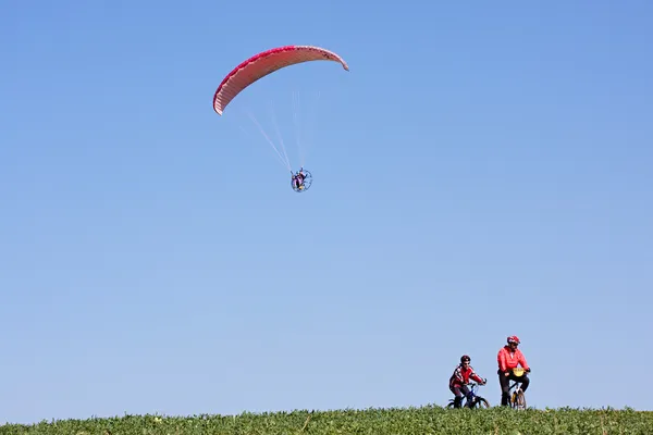 Powered paraglider and cyclists — Stock Photo, Image