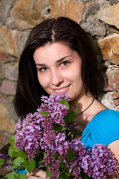 Glad ung kvinna med blomma — Stockfoto