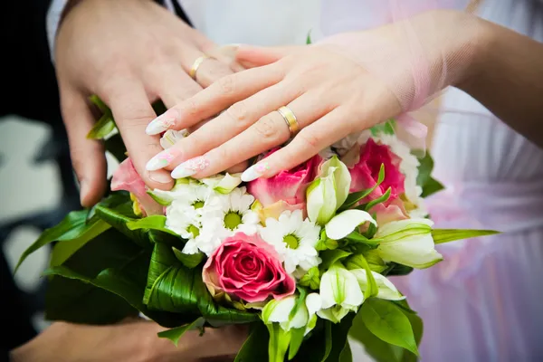 Hands of newly married with wedding bouq Royalty Free Stock Photos