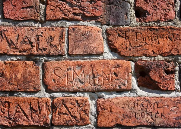 Inscriptions ciselées dans un mur de briques — Photo