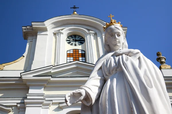 Jungfrau Maria weiße Statue gegen Kirche — Stockfoto