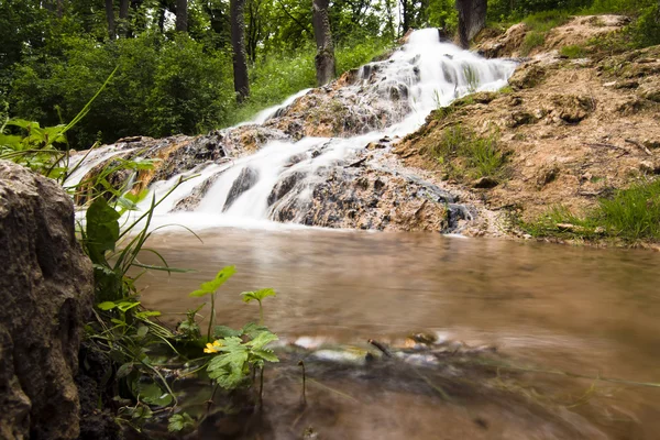 Vatten falla av en bäck — Stockfoto
