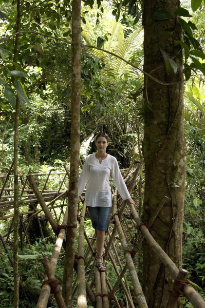 Das Mädchen geht auf die Bambusbrücke. — Stockfoto