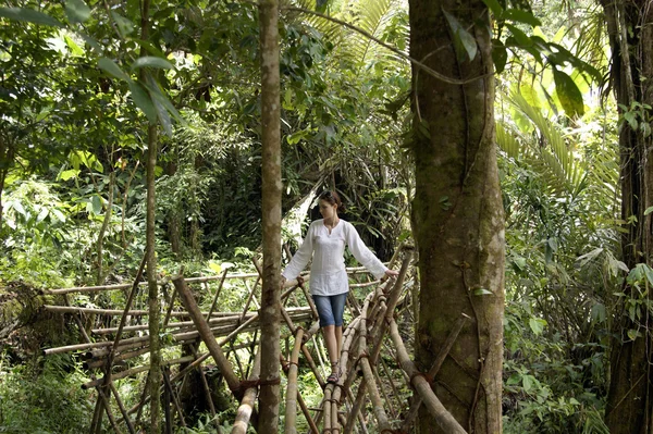 stock image The girl goes on the bamboo bridge.