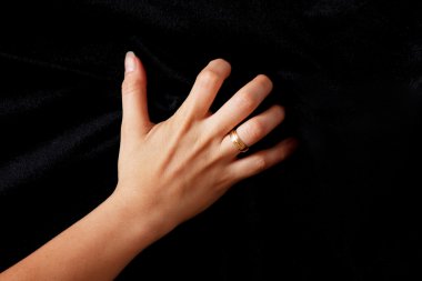 woman scratching cloth as a sign of anger over black background clipart