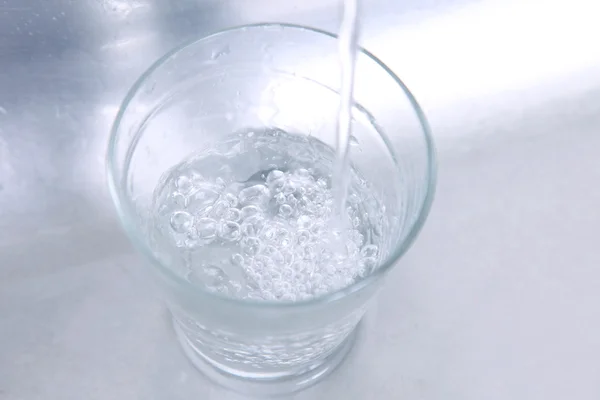 Recipiente Vidrio Que Recibe Agua Sobre Fondo Cromado — Foto de Stock