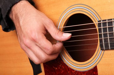 Hands of man playing an acoustic guitar wood clipart