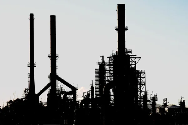 Silhuett av ett oljeraffinaderi med skorstenar — Stockfoto
