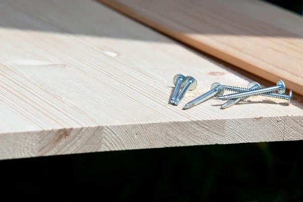 Шість сталевих гвинтів на дерев'яній дошці — стокове фото
