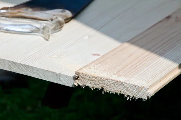 Velha serra deitada em tábuas de madeira — Fotografia de Stock