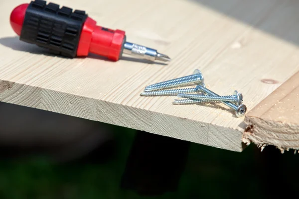 Screwdriver, screws and wood planks — Stock Photo, Image
