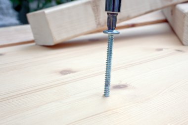 Screwdriver, screw and wood planks clipart