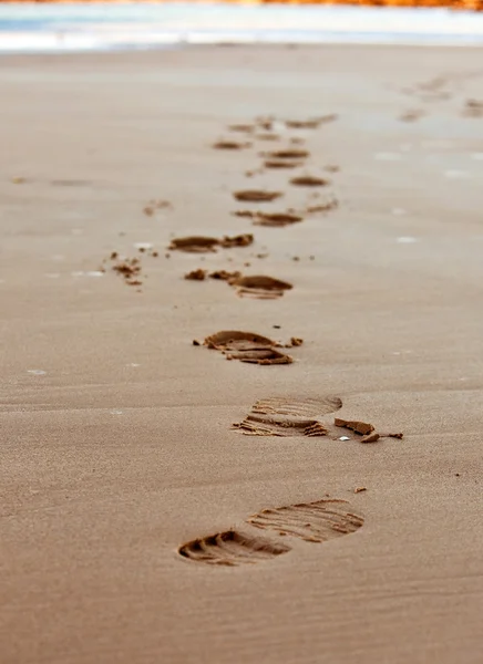 在沙的海海岸线上的脚印链 — 图库照片