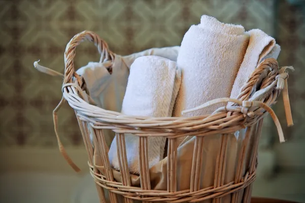Two white rolled towels in wicker basket — Stock Photo, Image