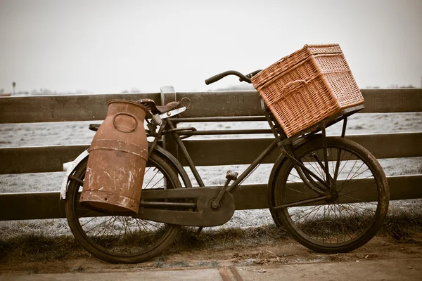Bicicleta velha com lata e cesta — Fotografia de Stock