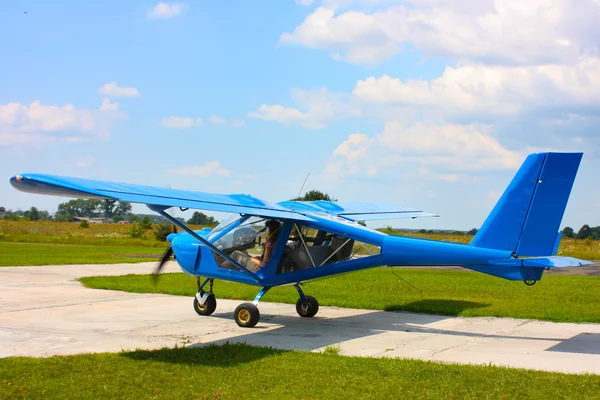 Kleine blauwe vliegtuig onder hemel — Stockfoto
