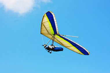 Hang glider flying in the mountains clipart