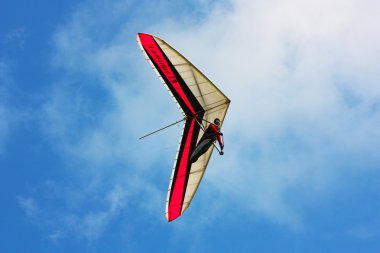 Hang glider flying in the mountains clipart