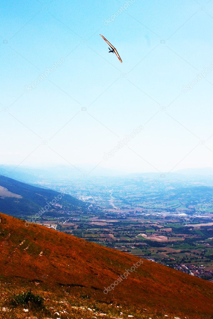 Hang glider flying in the mountains