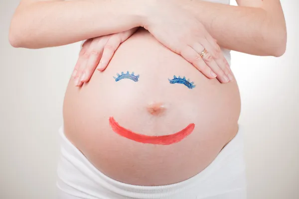 Рисование людей на беременном животе — стоковое фото