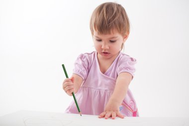 küçük kız boya kalemi ile çizer.