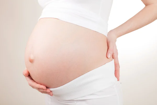 Pregnant woman holding her belly arms — Stock Photo, Image