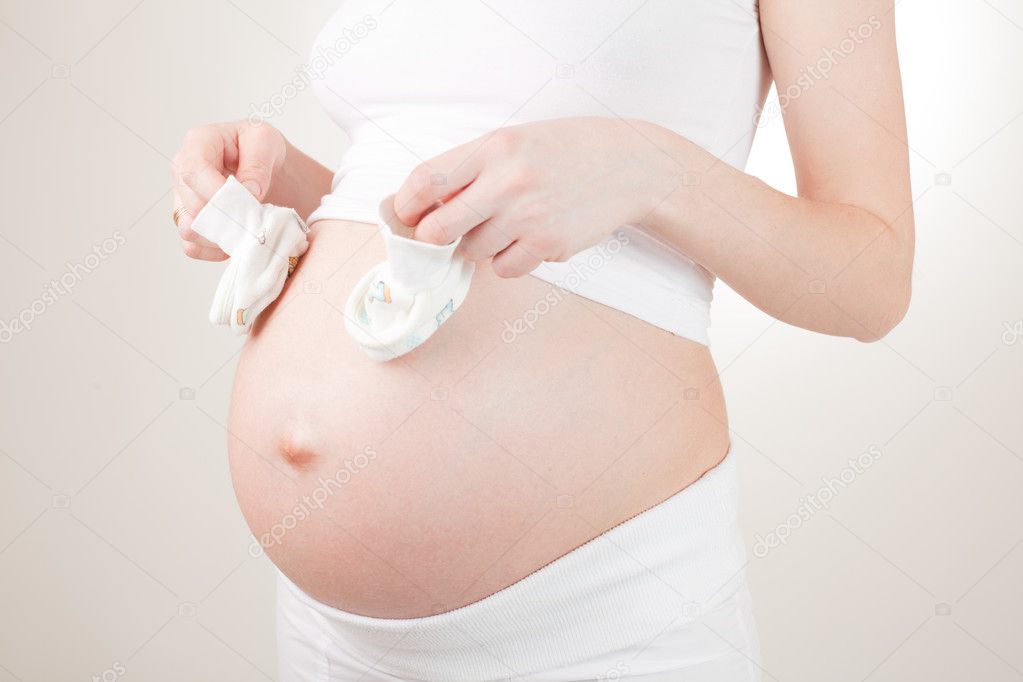 Pregnant woman and booties on white