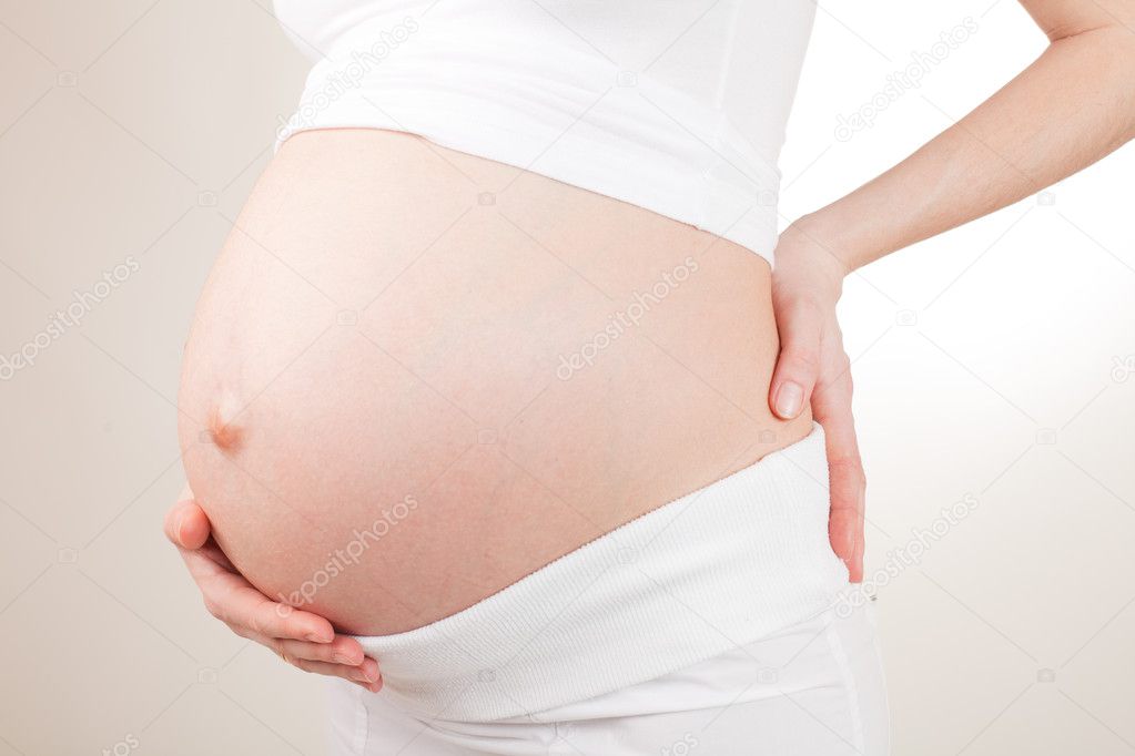 Pregnant woman holding her belly arms
