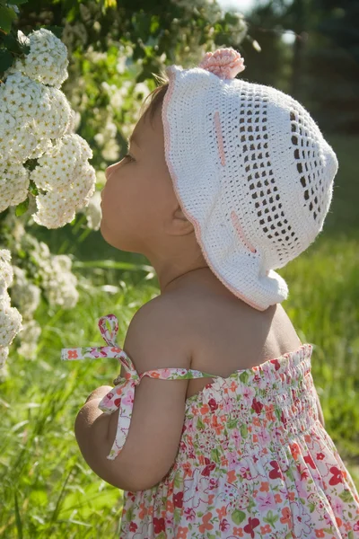 Child enjoys the scent of flowers — Stock Photo, Image