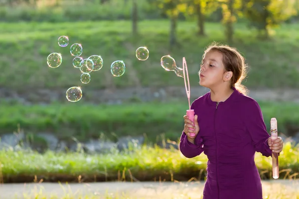 Malá holka foukání mýdlové bubliny — Stock fotografie