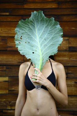 Young woman with cabbage leaf mask clipart