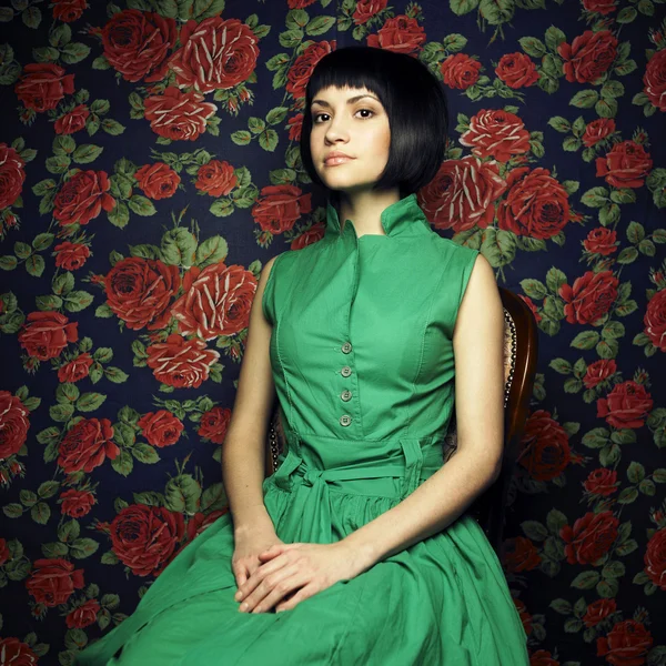 Dívka v zelených šatech, obklopen růže — Stock fotografie